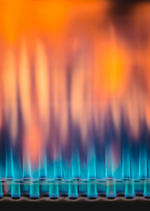 View of flame tongues burning in blaze and warming roaster cylinder for coffee roasting