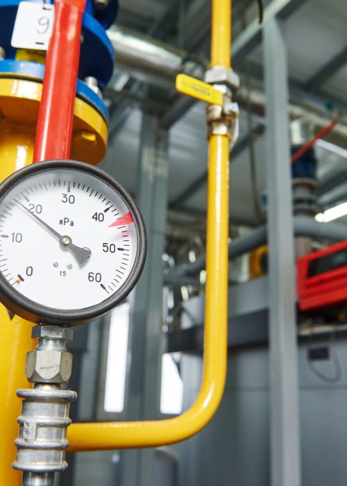 Closeup of manometer, pipes and faucet valves of gas heating system in a boiler room